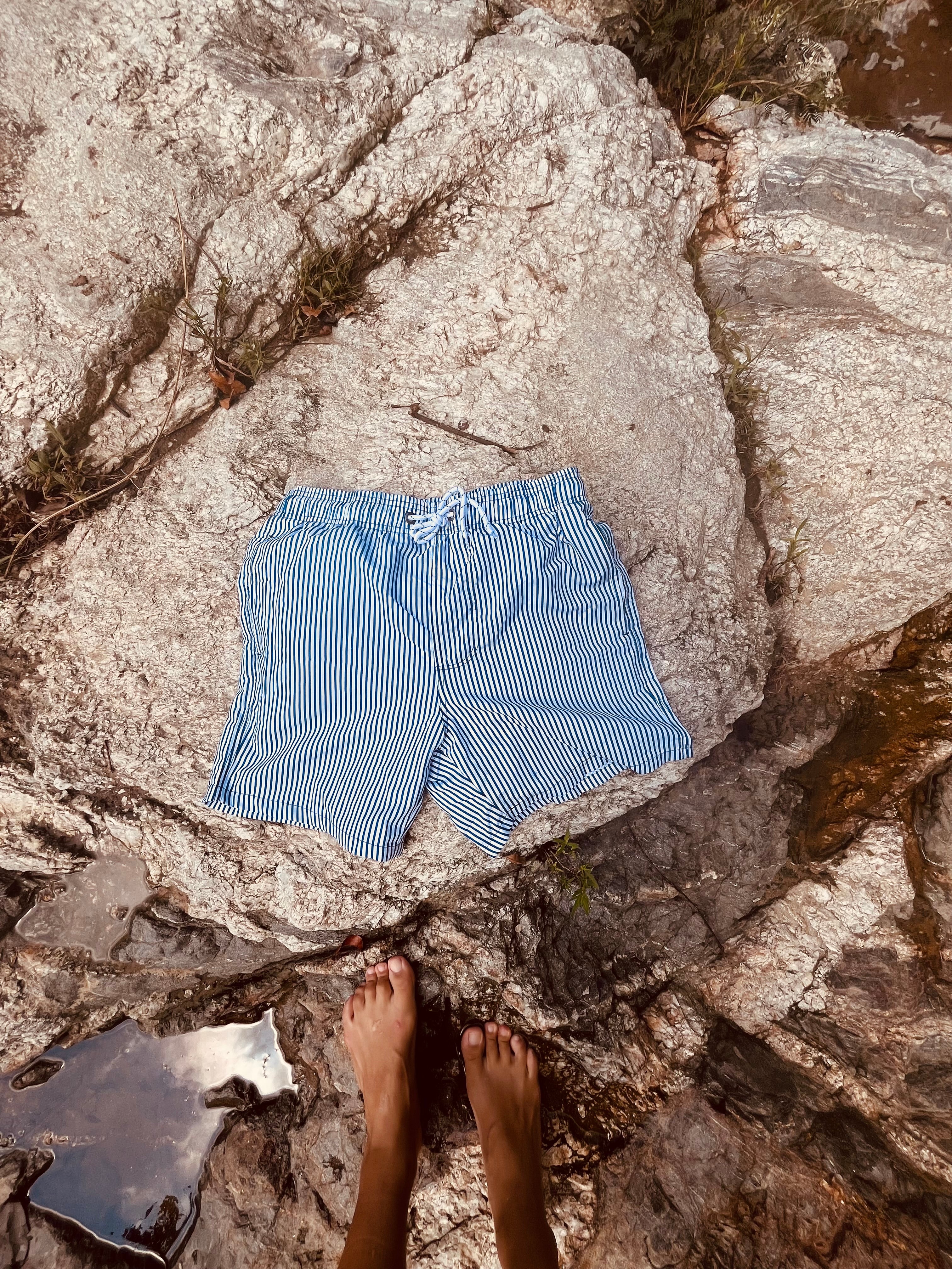 Swimming shorts with blue stripes. Shorts include zipped pockets. Shorts from Loa. 